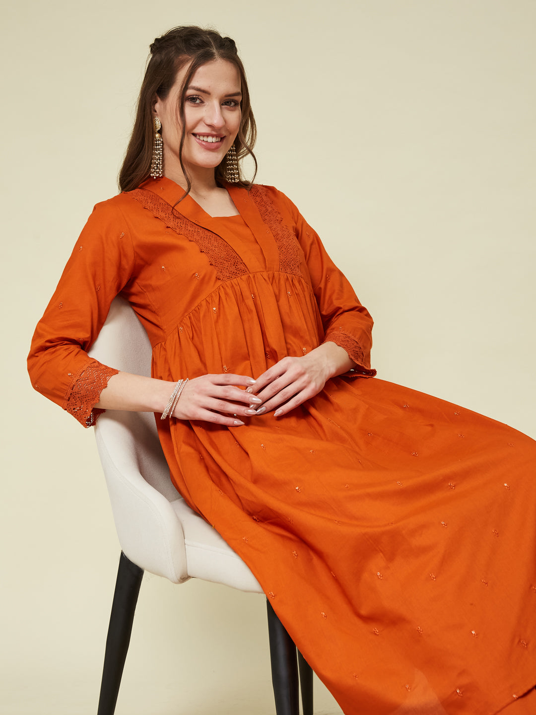 A woman sitting on a chair wearing an orange cotton embroidered co-ord set. | Orange Cotton Embroidered Co-ord Set for Women