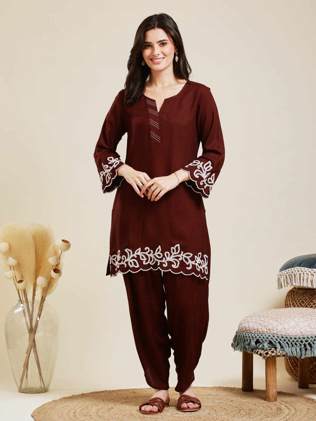 Woman wearing a maroon traditional outfit with white embroidery in a minimalistic setting. Coffee Rayon Embroidered Co-ord Set for Women