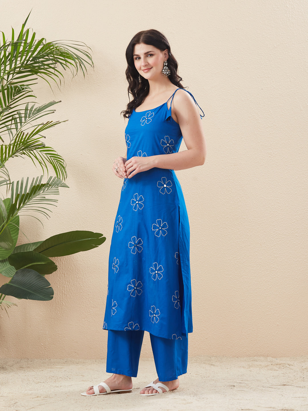 Woman wearing a blue floral dress and pants against a beige  Blue Cotton Embroidered Kurta with Palazzo Set for Womenbackground